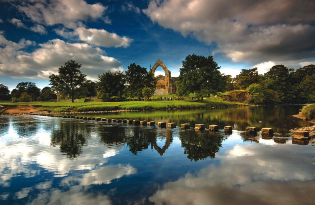 Easter in Yorkshire 2025: Family Activities, Egg Hunts, and Spring Events Post image 11 view of Bolton Abbey over lake