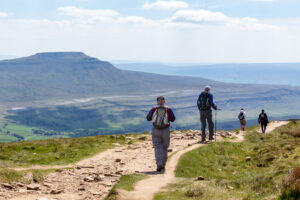 Nidderdale Page image 7 Image name walkers descending whernside view of ingleborough sunny yorkshire the 1 image from the post Nidderdale in Yorkshire.com.