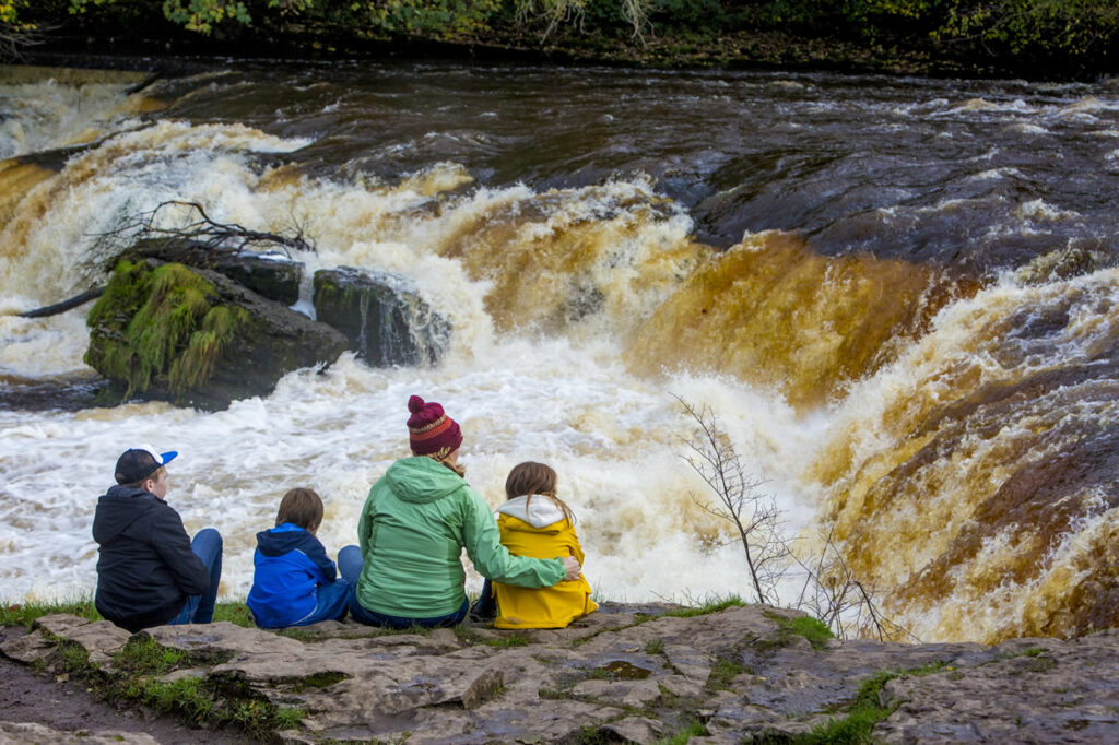 Aysgarth Page image 1 A family sitting in front of Aysgarth Falls