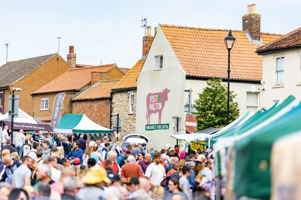 Shopping in Malton - For Locals & Visitors Page image 6 Image name Crowds Market Place East. Malton Food Festival 3 June 2022. Photo Credit milnerCreative on behalf of Visit Malton the 3 image from the post Shopping in Malton - For Locals & Visitors in Yorkshire.com.