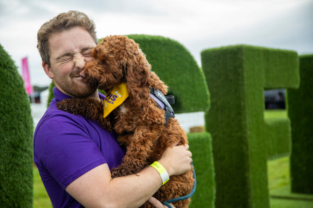 Yorkshire's DogFest 2024: A Pawfect Weekend for Canine Enthusiasts at Harewood House Post image 3 Image name Man cuddles dog the 3 image from the post Yorkshire's DogFest 2024: A Pawfect Weekend for Canine Enthusiasts at Harewood House in Yorkshire.com.