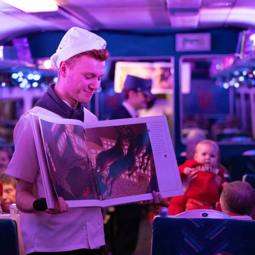 All Aboard THE POLAR EXPRESS™ Train Ride at Wensleydale Railway Post image 3 Image name Chef reading the Polar Express book the 3 image from the post All Aboard THE POLAR EXPRESS™ Train Ride at Wensleydale Railway in Yorkshire.com.