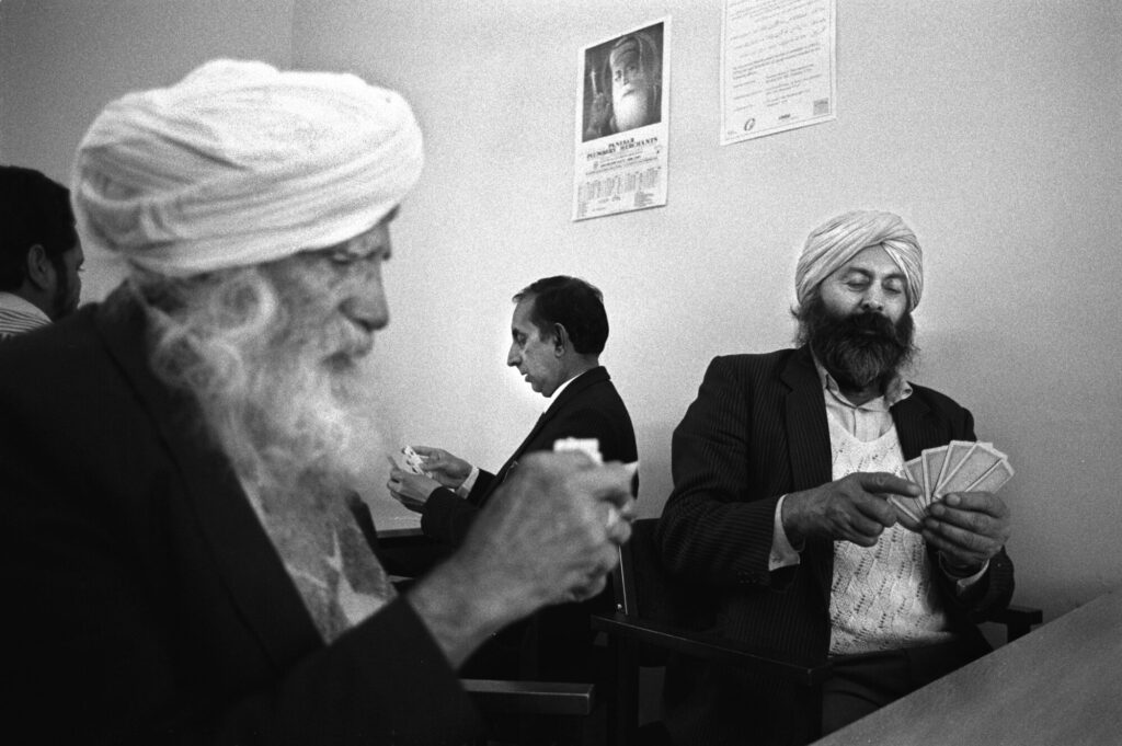 Image name 26409 Playing cards at the Indian Workers Association by Tim Smith Playing cards circa later 80s early 90s IWA 032 Tim Smith 1 the 7 image from the post Bradford 2025: What Were The Secret Daytimer Parties For South Asian Youth In The 1980s? in Yorkshire.com.